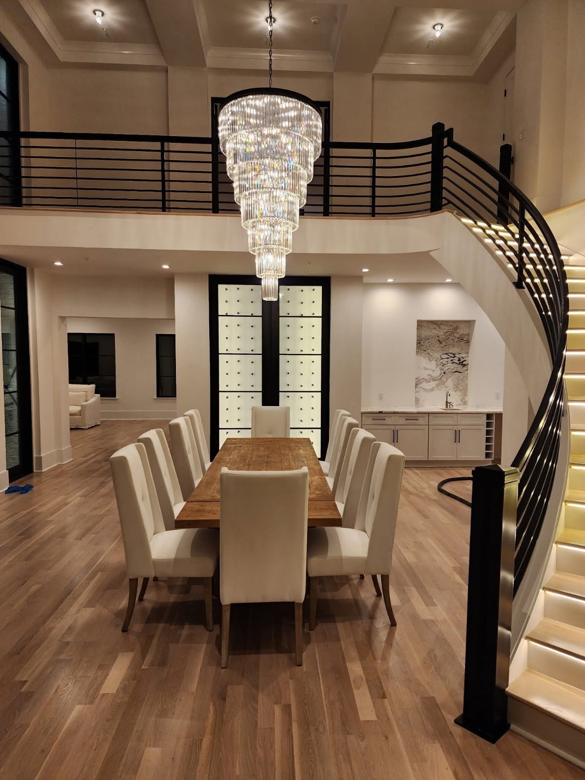 Finished custom dining room with a chandelier, curved staircase, and black metal railings